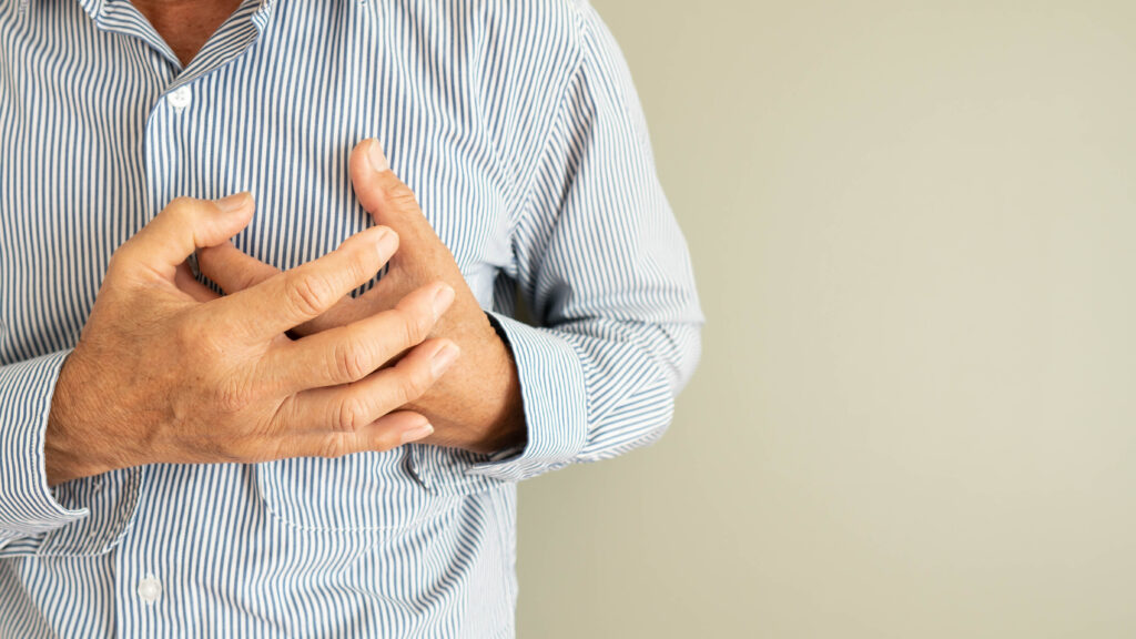 Man holding his chest due to a heart pain