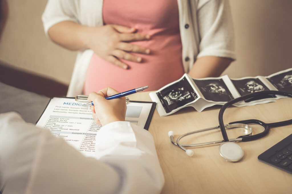 Pregnant woman consulting with doctor in medical facility