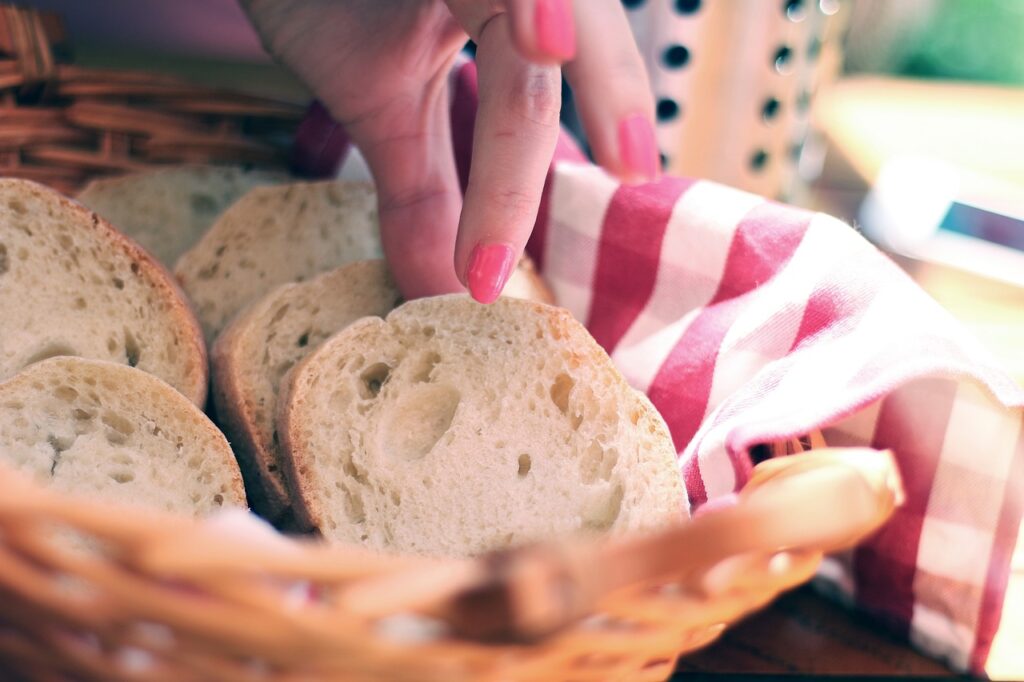Woman's hand picking up a slice of bread from a basket, restaurant