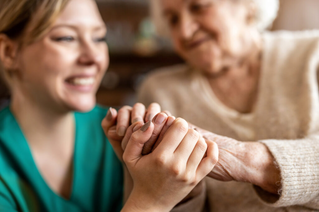 Older and younger woman holding hands and smiling
