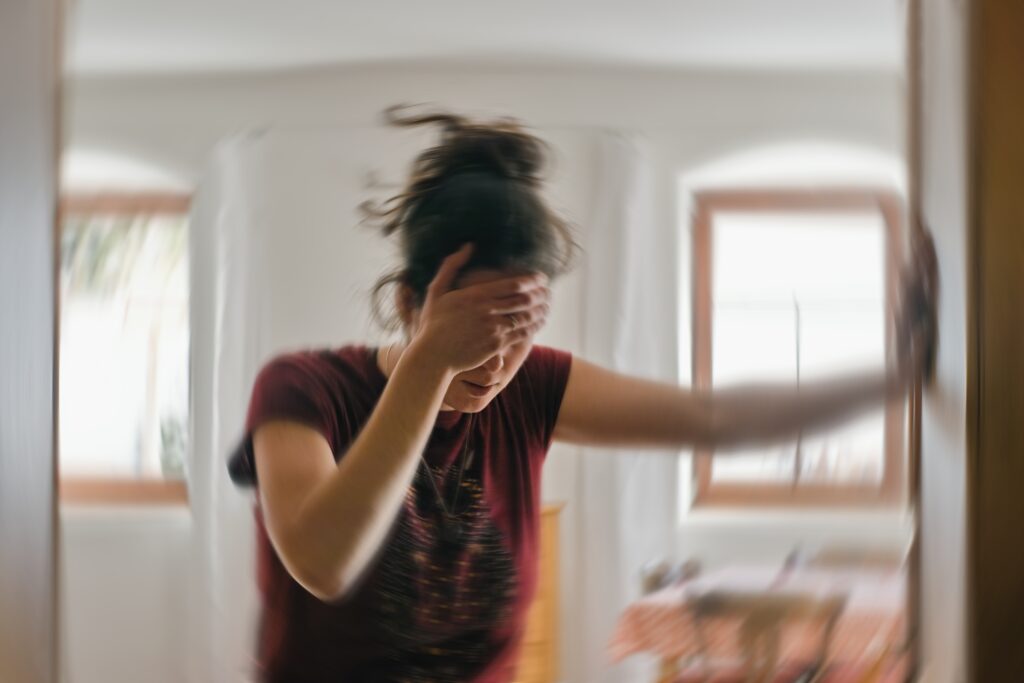 Blured photo of a woman suffering from vertigo or dizziness or other health problem of brain or inner ear.